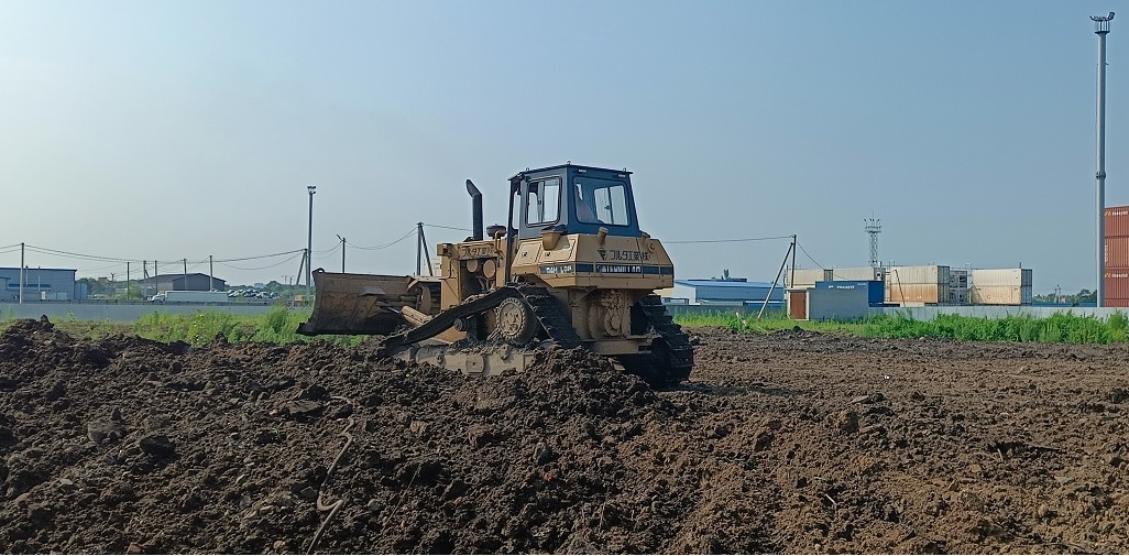 Бульдозер и экскватор роют и копают котлованы в Томской области